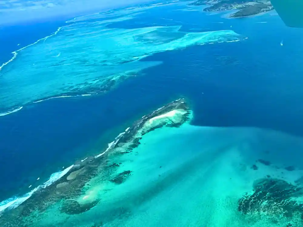 A deep blue channel meeting a pale sandbank ringed with turquoise