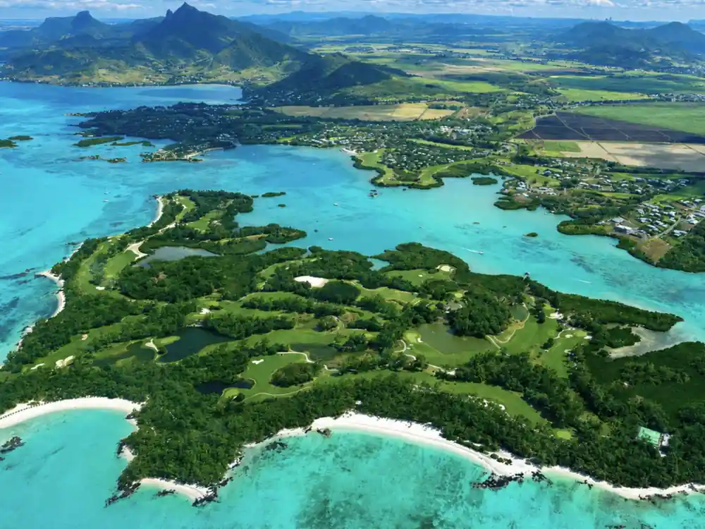 The golf island from above: fairways, lagoon inlets and white sand points