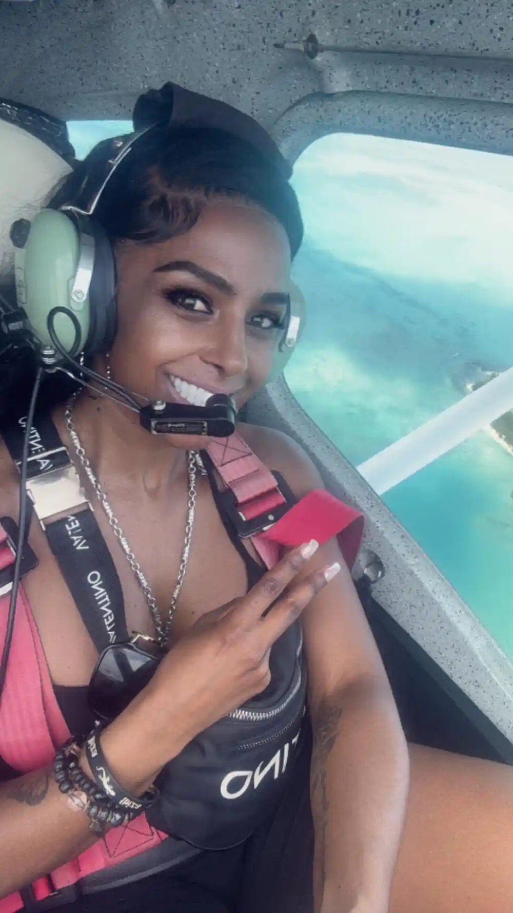 A passenger in the cabin wearing a headset, the lagoon through the window