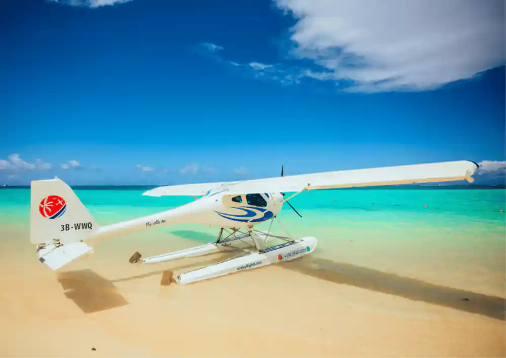 The seaplane parked on a bright sandbar with turquoise on both sides