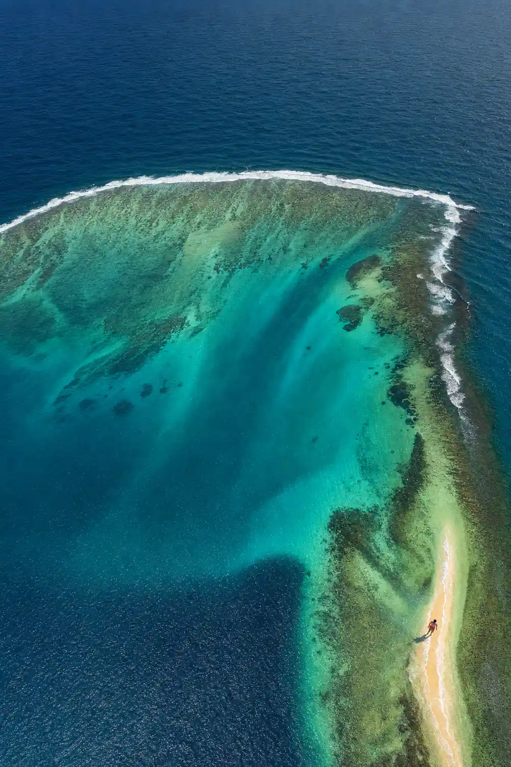 Sediment fanning off a reef shelf into deep green water