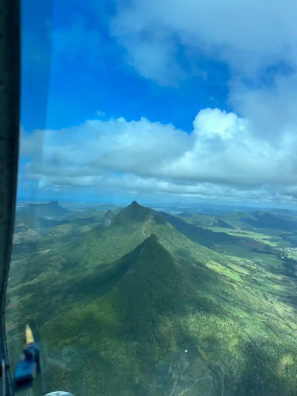 A sharp green peak from the air with ridges falling to the coast